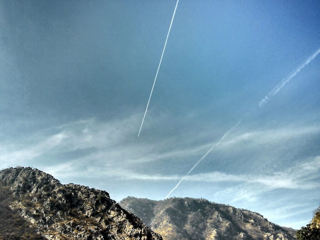 Cielo con varias estelas de avión cruzadas, algunas ensanchadas como nubes