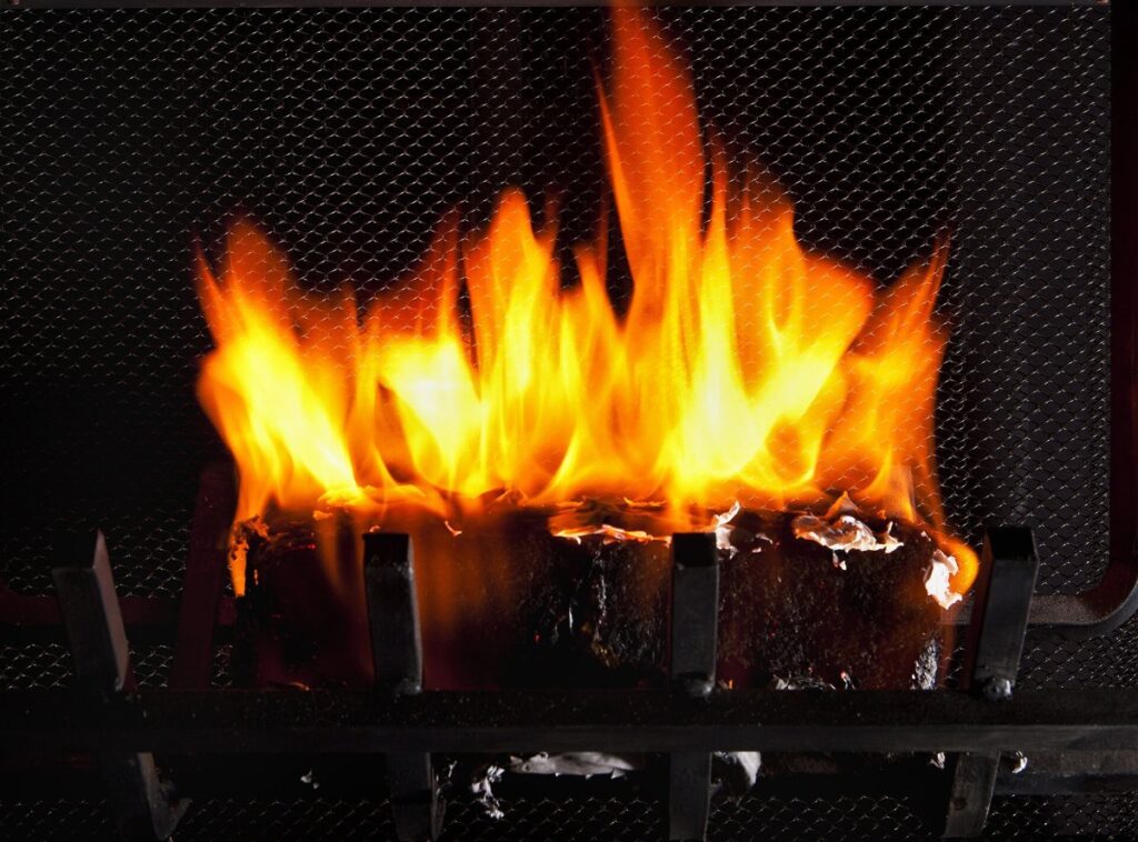 Troncos ardiendo con llamas altas dentro de una chimenea