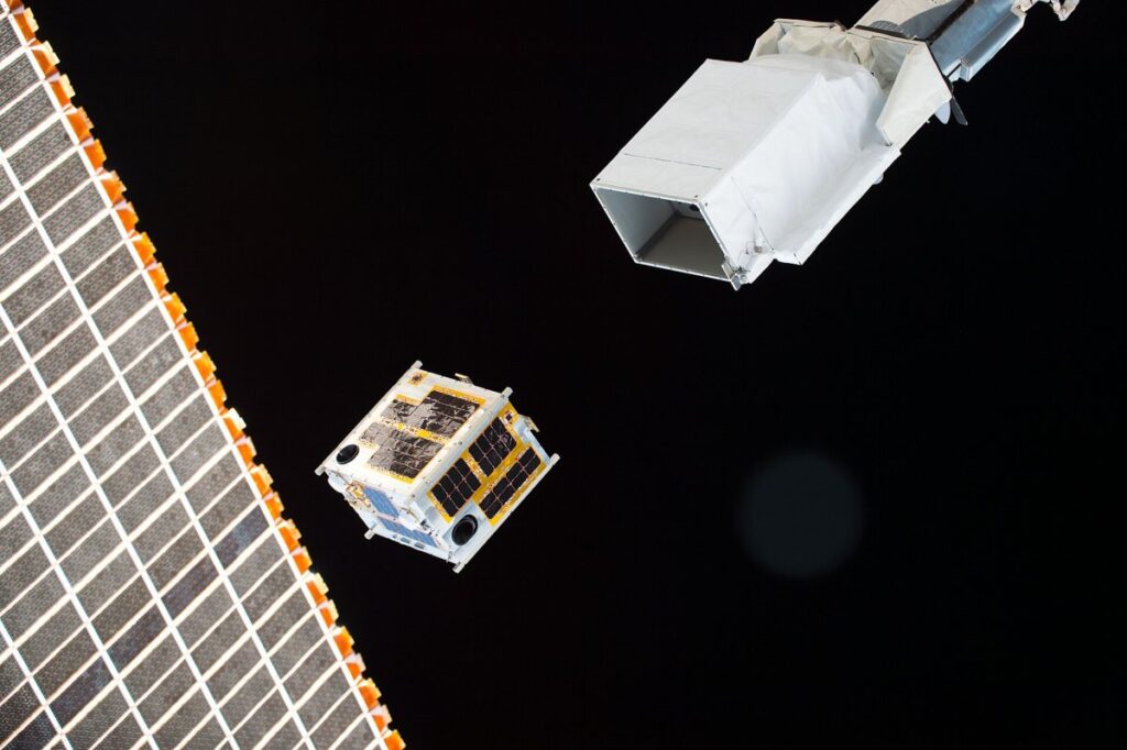 Satélite con grandes paneles solares sobre el fondo de la Tierra