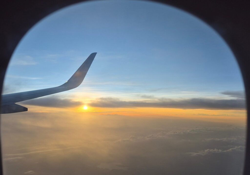 Amanecer visto desde la ventanilla de un avión sobre las nubes